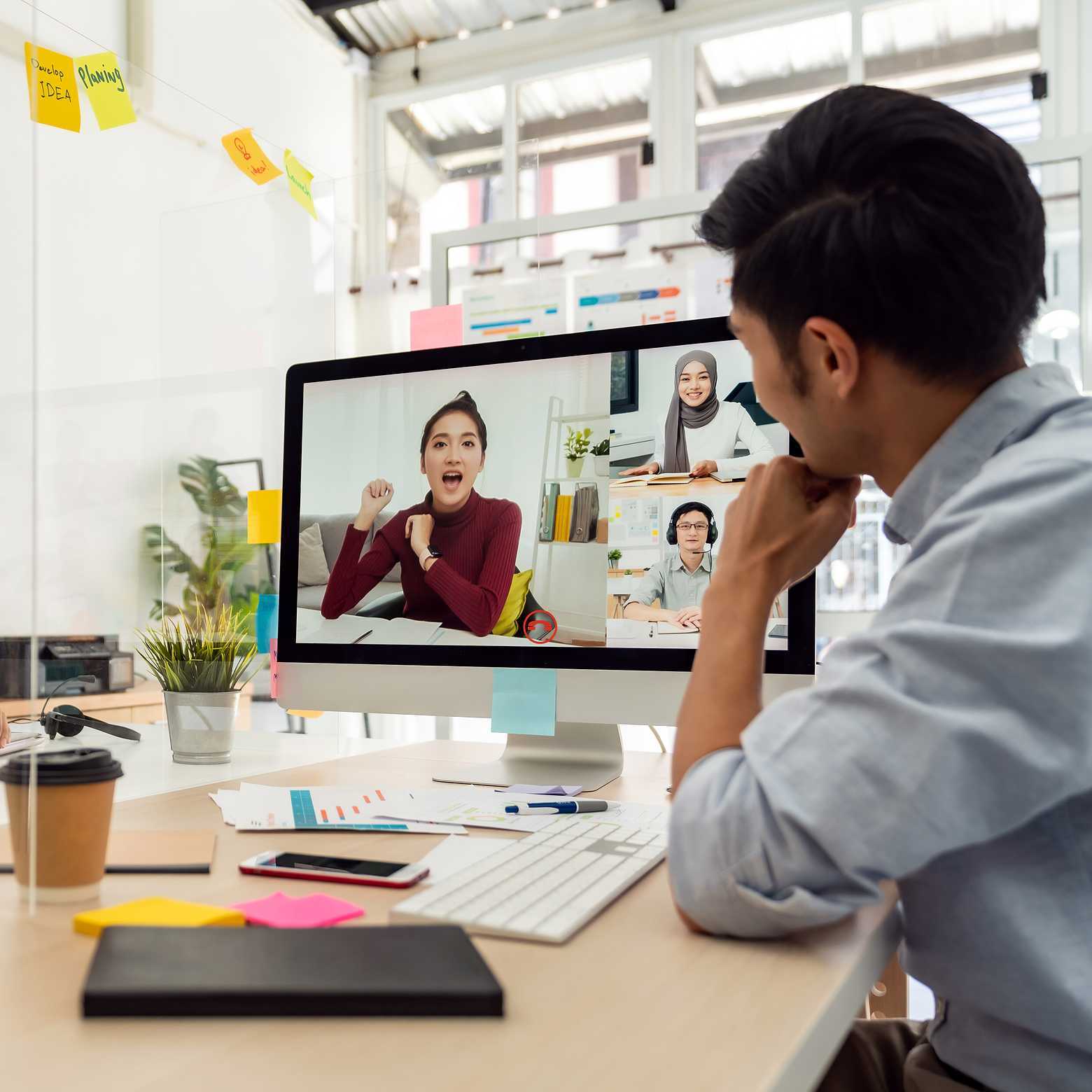 Seamlessly connecting hybrid teams, employees gather around Boom Collaboration Equipment in a dynamic boardroom setting.