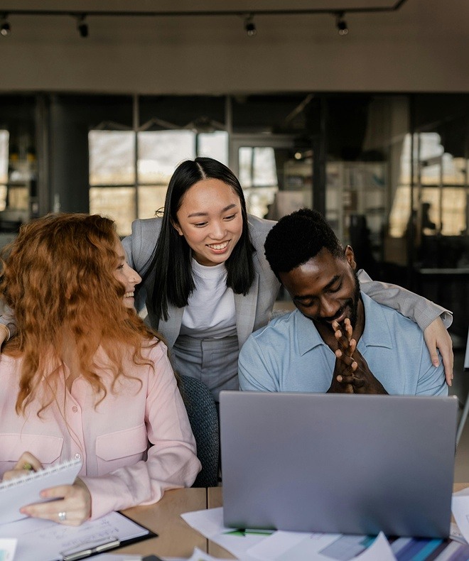 Three women smiling during a video call from home. Utilizing Boom Collaboration Equipment transforms meetings into dynamic, engaging experiences. 