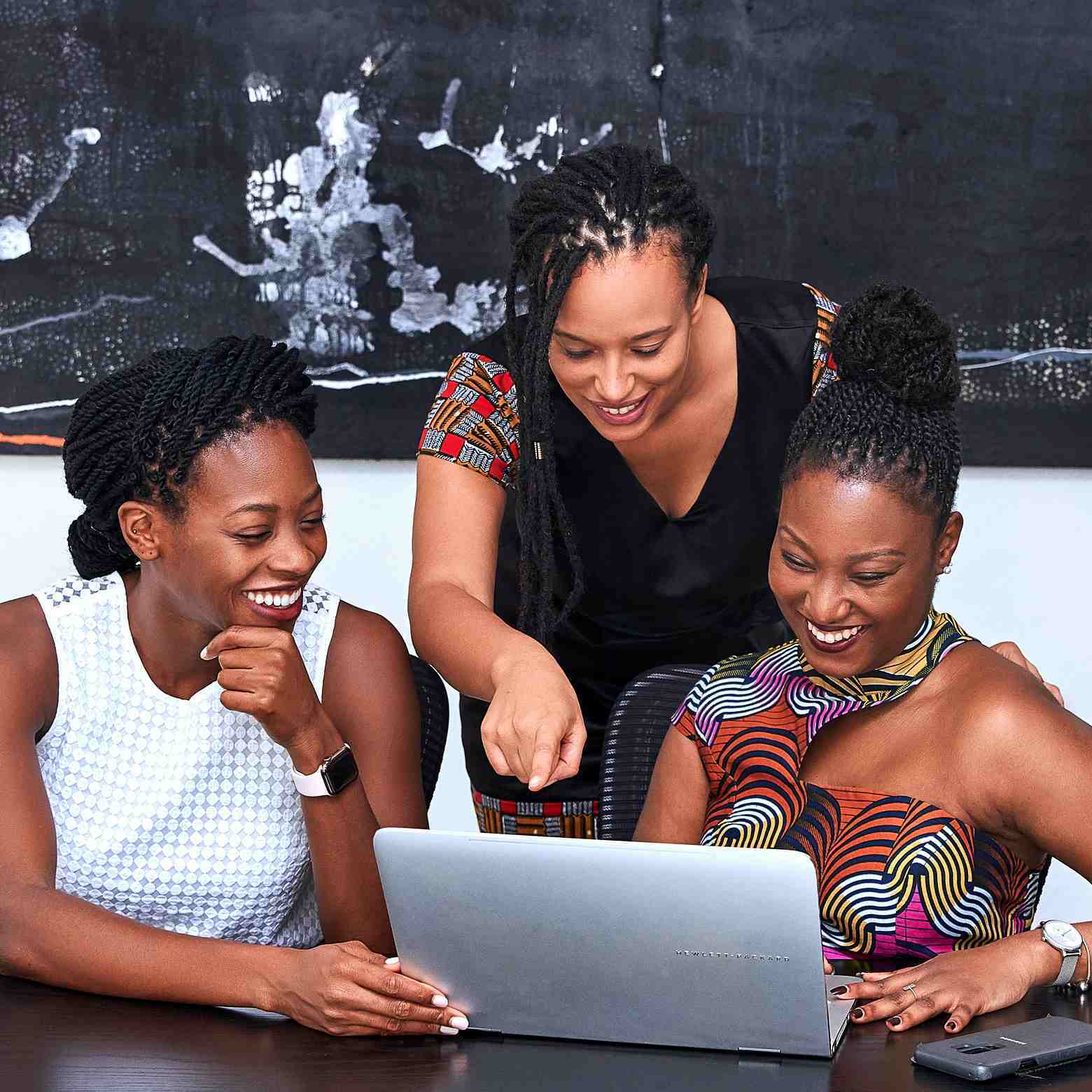 Three ladies talking and laughing on a video call, showcasing how Boom Collaboration equipment enables better meetings with high-quality audio and video.