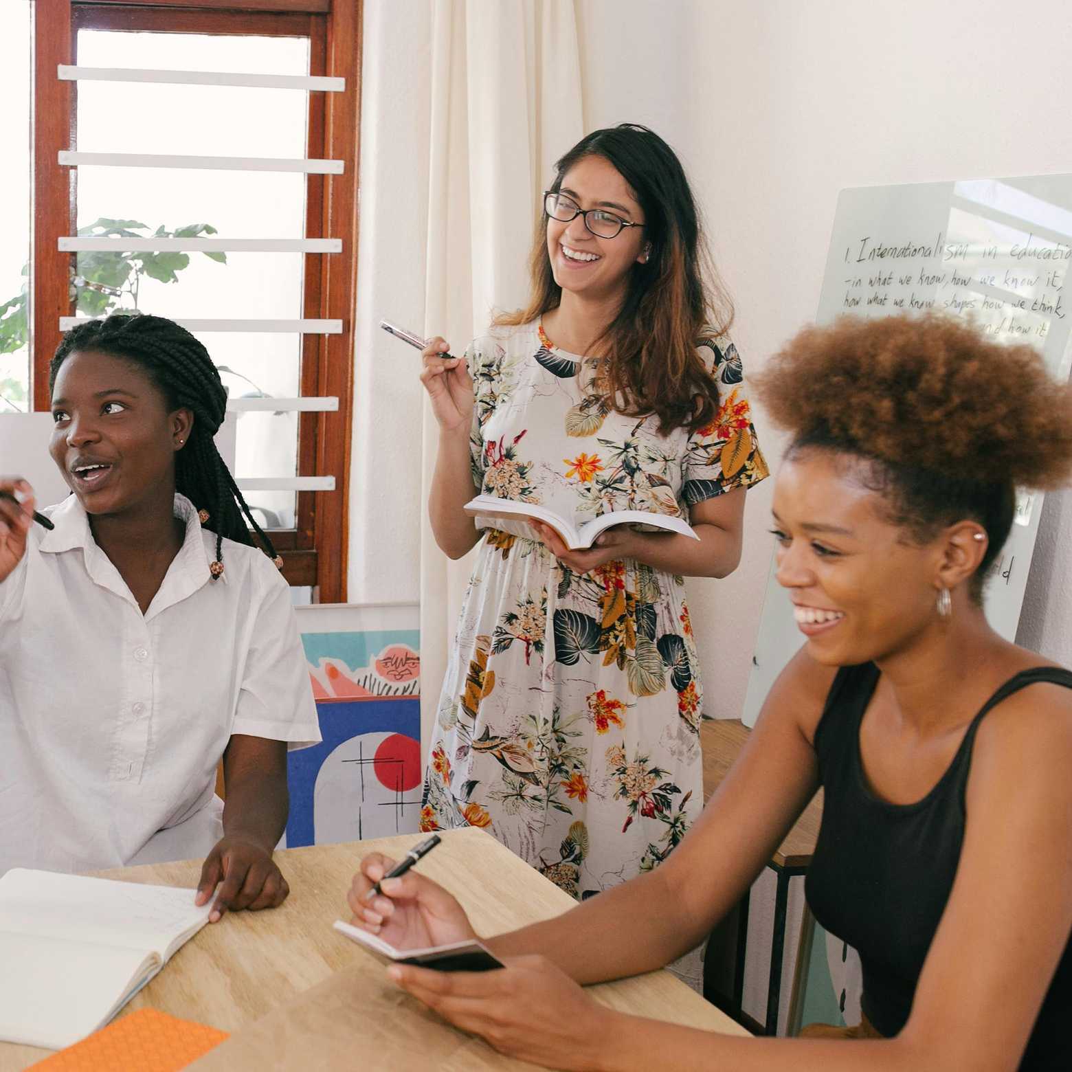 Seamlessly connecting hybrid teams, employees gather around Boom Collaboration Equipment in a dynamic boardroom setting.