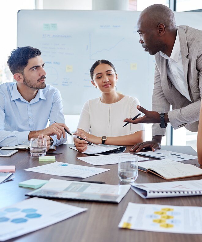 Image of young business coworkers discussing and analyzing work statistics and startup plans using Boom’s equipment to ensure seamless communication and productivity. 