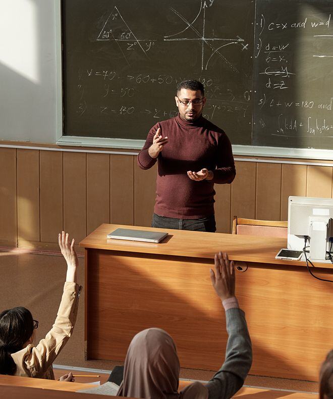 Students participating during a lecture by raising their hands in response to the professor's question. With Boom Collaboration Equipment, classroom interactions are elevated, promoting clear communication and active engagement.