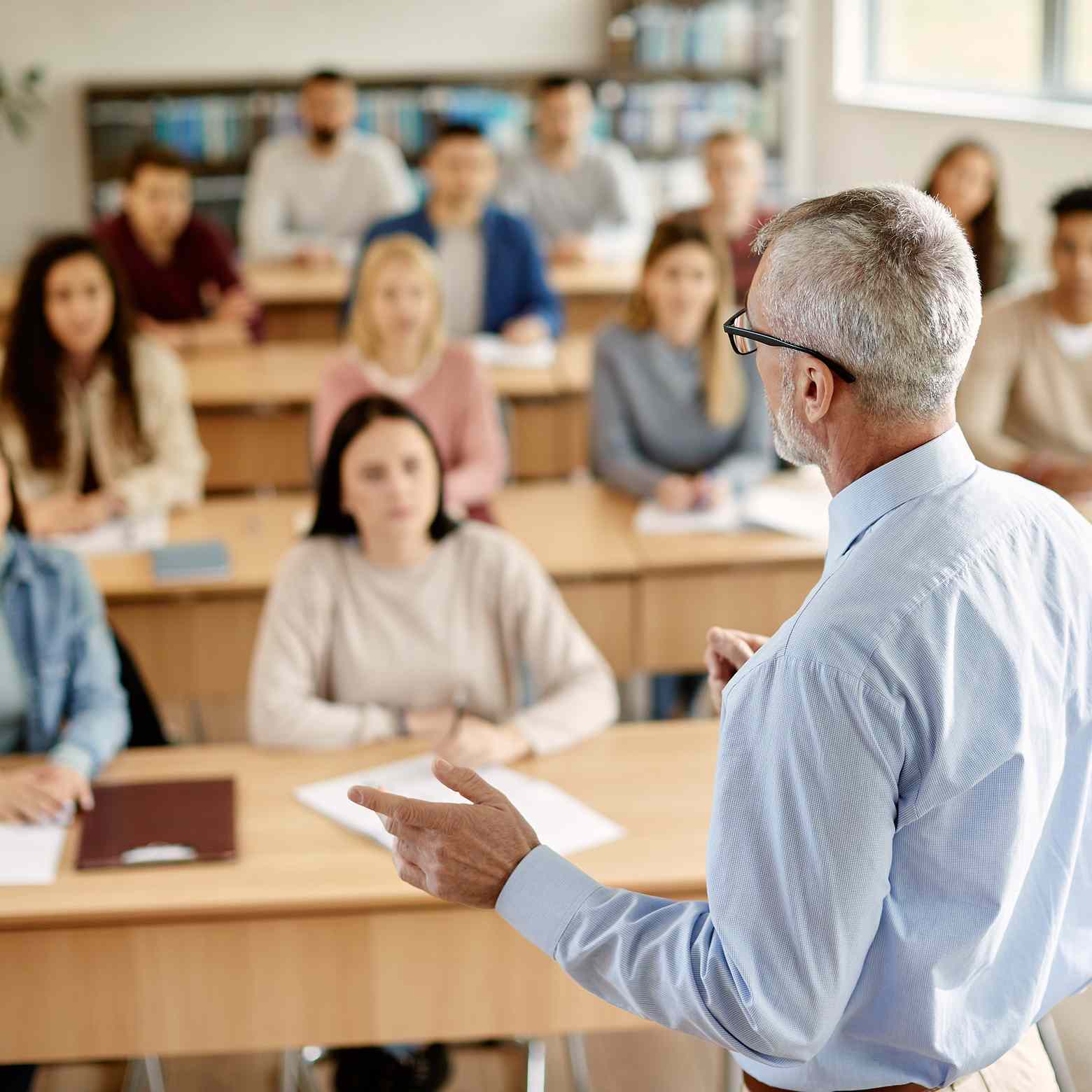 A teacher engages with a student during a lecture in a university classroom. Thanks to Boom Collaboration technology, classrooms are empowered, fostering higher engagement and interactive learning experiences.