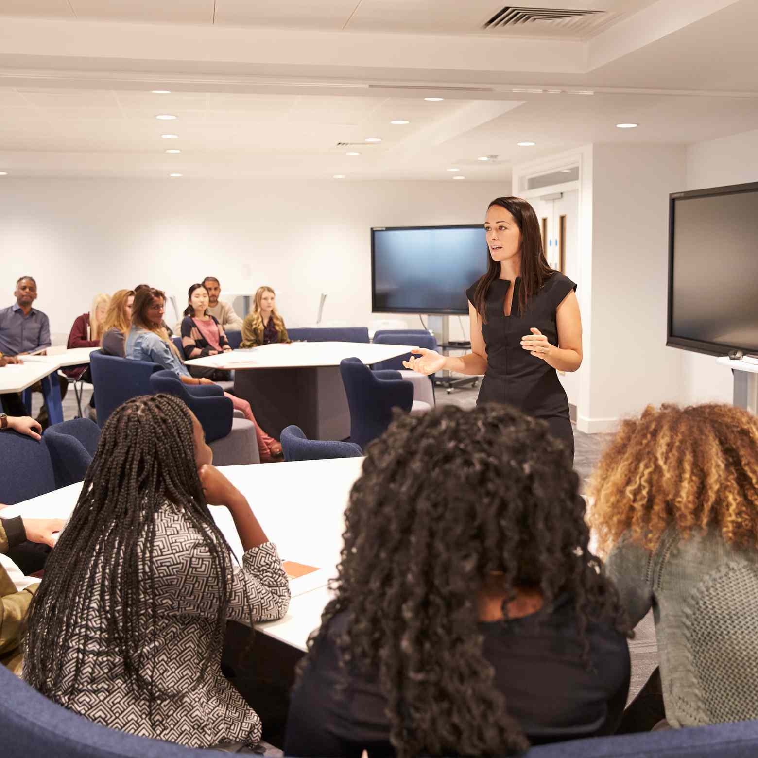 Image showcasing a teacher addressing university students in a classroom setting. With Boom Collaboration equipment, interactive learning is facilitated through video and audio conferencing solutions.