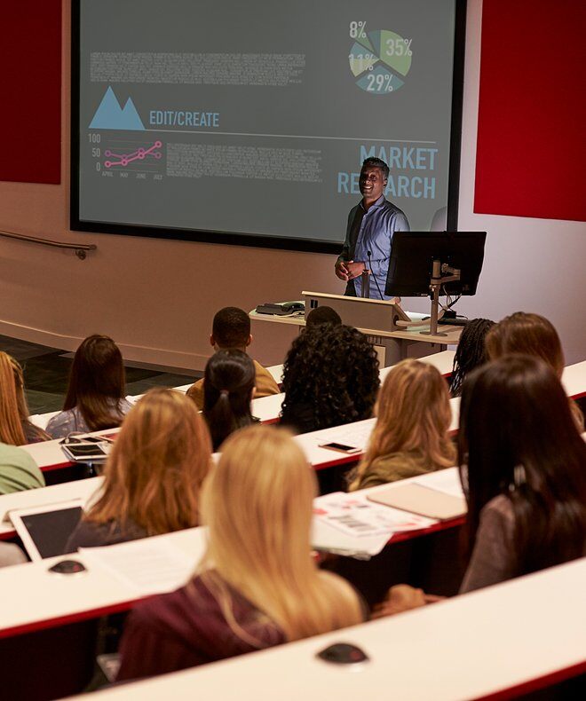 Students listening to a lecture in a university classroom. Boom Collaboration video and audio solutions enhance education by providing clear, high-quality communication, enabling better understanding and engagement during lectures.