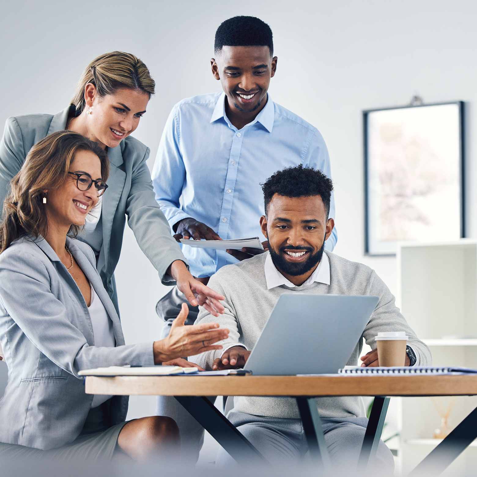 Image of a business team reviewing a digital website presentation on a laptop during a meeting. Boom’s camera and audio solutions enhance meetings and boosts productivity.