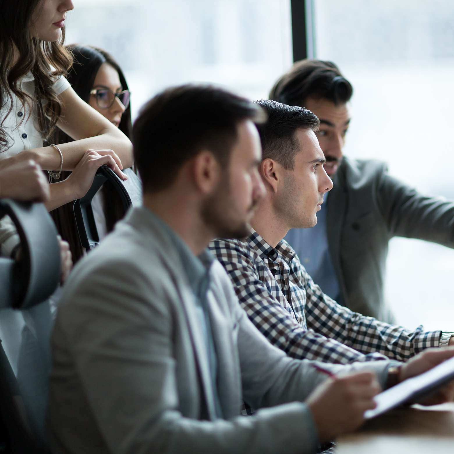 Three young men looking at a screen, engaged in a meeting powered by Boom Collaboration Equipment.