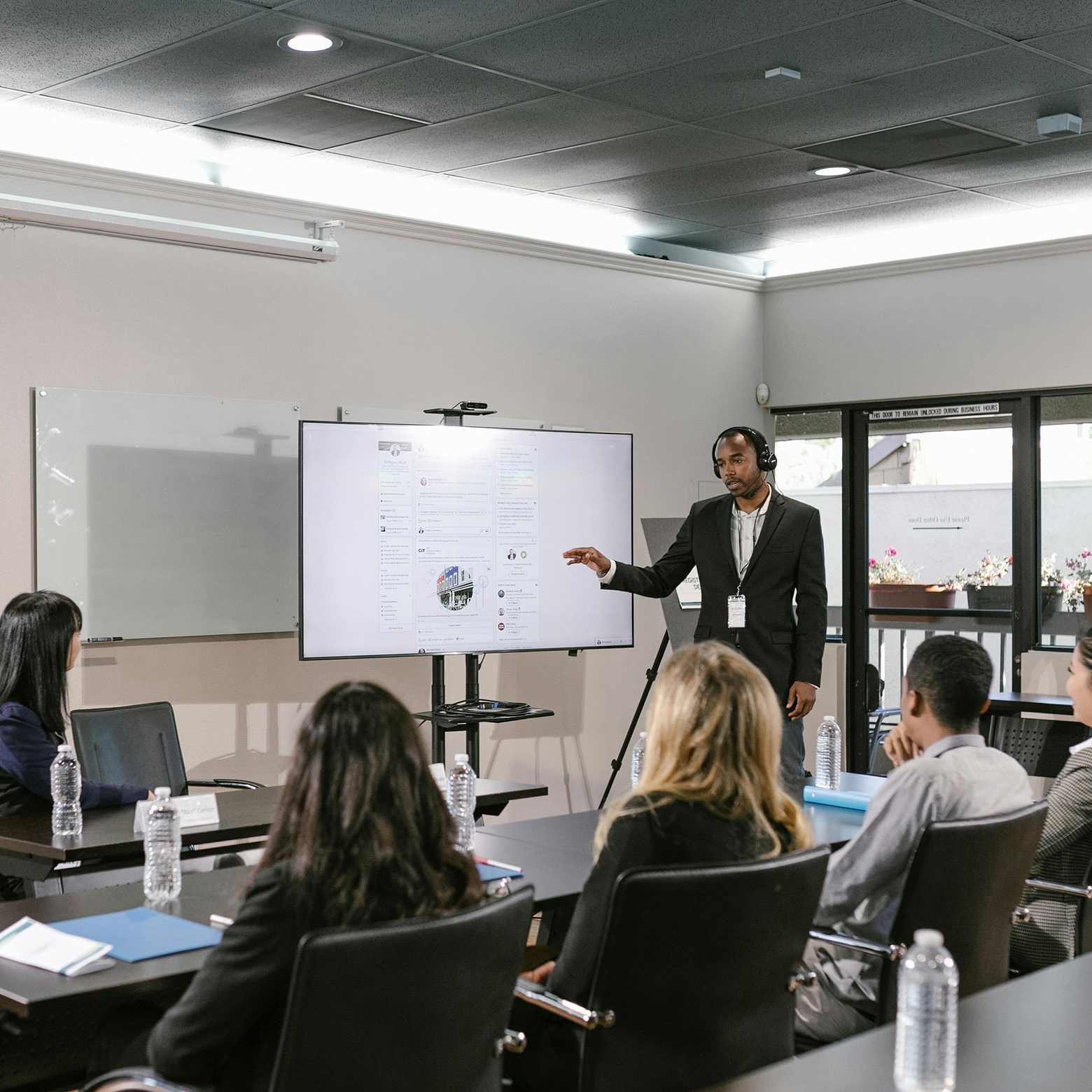 A group of coworkers attentively listening to a presentation, with Boom equipment enhancing the audio quality for a more immersive experience.